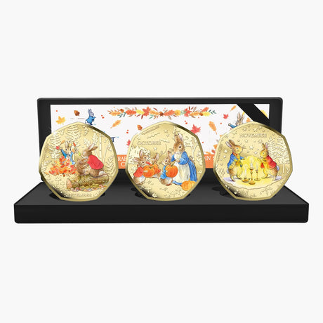 Peter Rabbit Tales of Autumn September, October and November coloured coins displayed in a black presentation case.