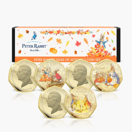 Peter Rabbit Tales of Autumn three-coin set showing coloured reverses and King Charles III obverses in front of illustrated packaging.