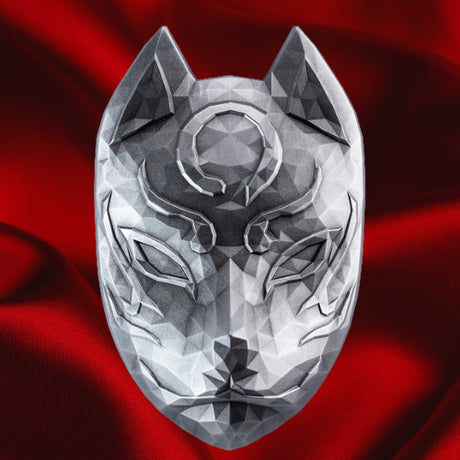 Front view on red satin: KOMSCO Kitsune silver stacker showing a faceted fox mask with pointed ears, narrow eyes and sculpted forehead markings, against red satin.