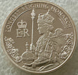 Silver coin featuring a monarch with decorative elements and text on a textured background