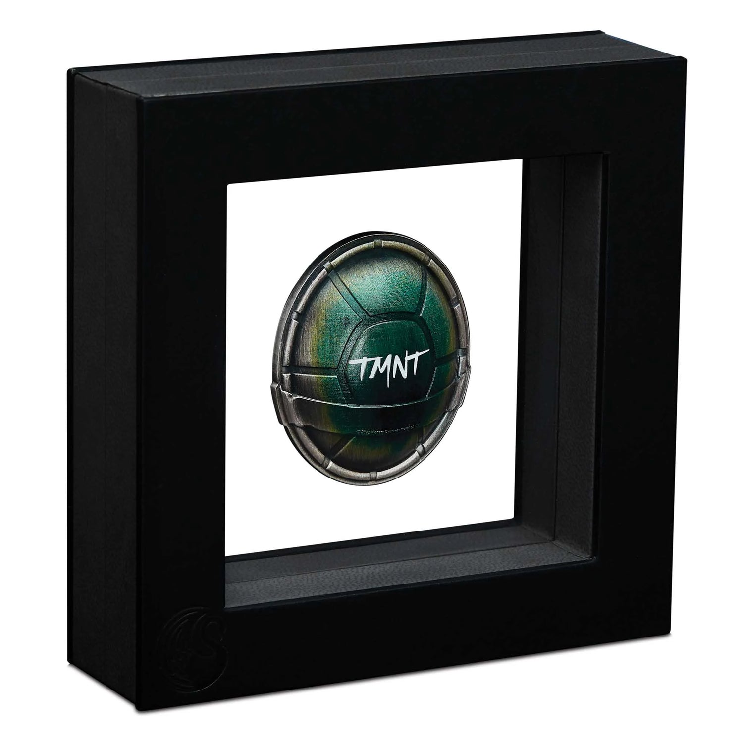 Black framed display case with a green and black object featuring 'TMNT' branding on a white background.