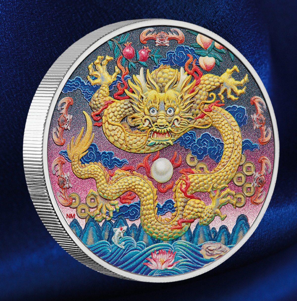 A round silver collectible coin featuring a highly detailed, colorful Chinese dragon design on a dark blue satin fabric background.