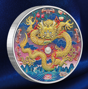 A round silver collectible coin featuring a highly detailed, colorful Chinese dragon design on a dark blue satin fabric background.