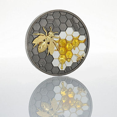 Decorative coin with bee and honeycomb design on a white background