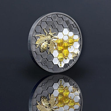Decorative coin with bee and honeycomb design on a dark background