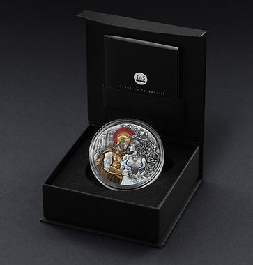 Silver coin with a decorative design in a black box on a dark background