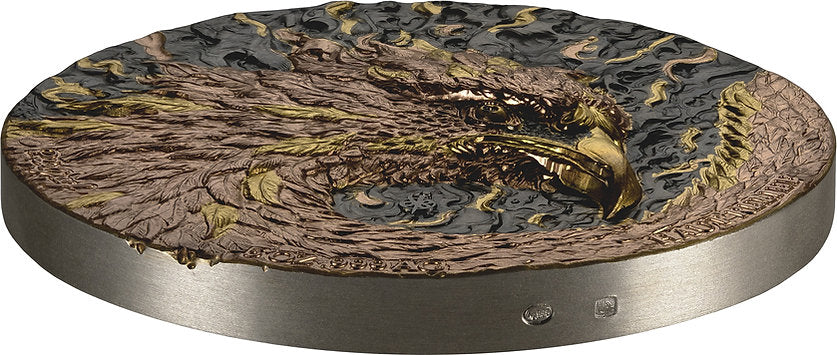Decorative round object with an eagle design on a metallic base