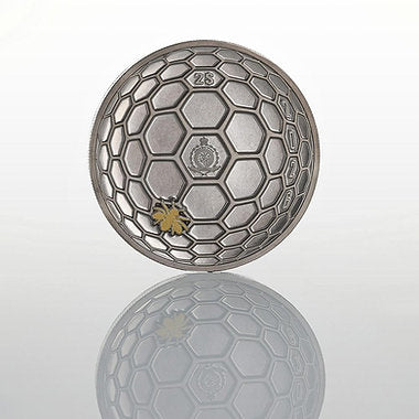 Silver metallic ball with honeycomb pattern and logo on a reflective surface