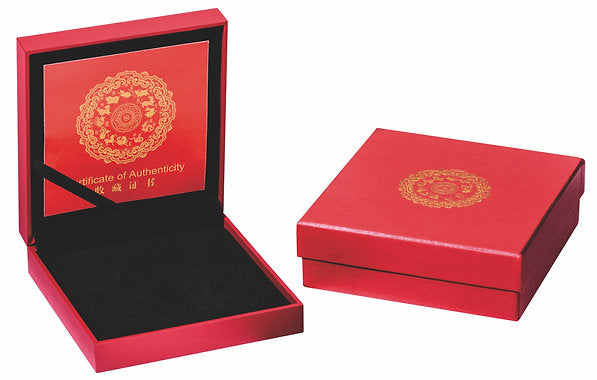 Red jewelry box with gold emblem and black interior on a white background
