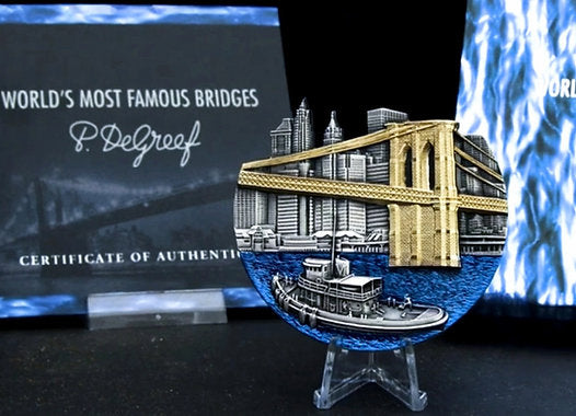 Metallic model of a bridge with a boat on a stand, in front of a book titled 'World's Most Famous Bridges'.