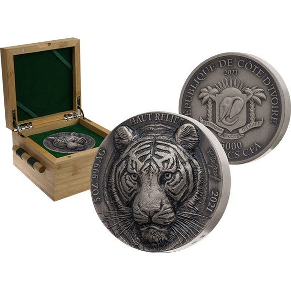 Silver coin with tiger design in a wooden box on a white background