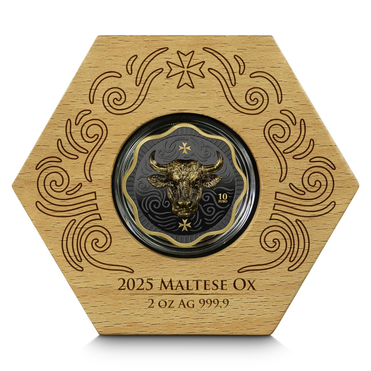 A hexagonal wooden presentation box engraved with decorative swirls and the text '2025 MALTESE OX 2 OZ AG 999.9', holding a circular coin featuring a gold bull head on a dark gray background.