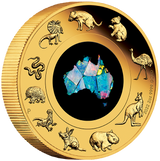 A 2oz gold coin featuring an opal insert with an image of the Australian continent and various Australian animals around it, including a kangaroo, emu, and koala. The coin also shows the profile of Queen Elizabeth II and the denomination of $200.