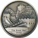 A silver coin featuring the Great Wall of China with high relief and antique finish, labeled as legal tender in Cambodia.