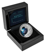 Niue 2022 Earth From Above silver proof coin showing Earth reflected in an astronaut’s visor sitting in it's open black laquer case.