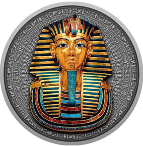 A close-up view of the detailed reverse side of the Niue 2022 2-ounce silver coin. The high-relief antiqued design centers on the legendary death mask of Pharaoh Tutankhamun, intricately embellished with selective yellow-gold gilding and deep blue accents on the nemes headdress. The top features the protective uraeus cobra and vulture symbols, while a traditional artificial beard accents the chin. The entire mask is framed by an etched border of historic Egyptian hieroglyphics.