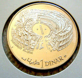 A 1969 Tunisia 1 Dinar coin with a proof finish, depicting the Colloseum/sports stadium.
